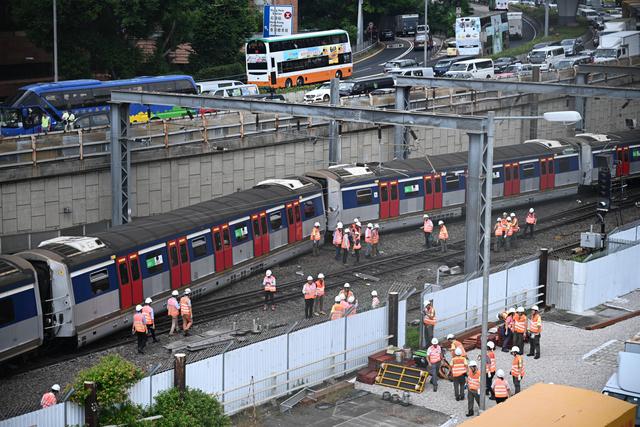 Los equipos de rescate investigan la escena del tren de pasajeros que se estrelló durante la hora pico fuera de la estación de trenes Hung Hom en el lado de Kowloon de Hong Kong. (Foto: AFP)