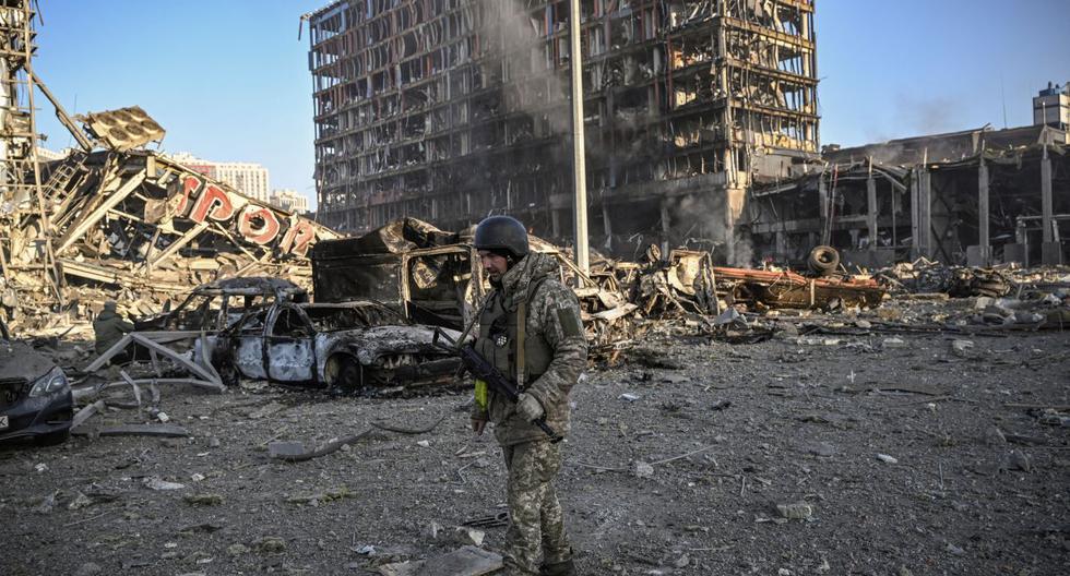 Un militar de Ucrania camina entre los escombros del centro comercial Retroville, en Kiev, destruido por un ataque ruso. (ARIS MESINIS / AFP).