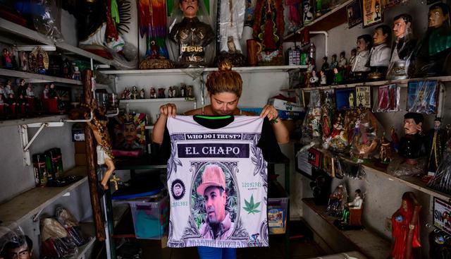 Vendedora muestra una camisa que representa un retrato de Joaquín "El Chapo" Guzmán en una tienda al lado de la capilla del narco Jesús Malverde en Culiacán. (Foto: AFP)