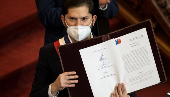 El presidente de Chile, Gabriel Boric, muestra el decreto que convoca a un plebiscito obligatorio el 4 de septiembre tras recibir el texto final de la nueva Constitución. (EFE/Alberto Valdés).