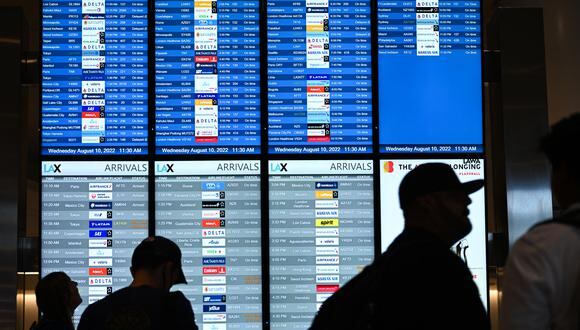 En esta foto de archivo tomada el 10 de agosto de 2022, los pasajeros miran los tableros de información de salida de vuelos en el área de expansión de West Gates en el Aeropuerto Internacional de Los Ángeles (LAX) en Los Ángeles, California. (Foto: Patrick T. FALLON / AFP)