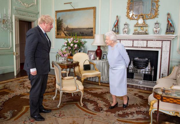 La reina Isabel II de Gran Bretaña saluda al primer ministro británico, Boris Johnson, durante una audiencia en el Palacio de Buckingham el 23 de junio de 2021. (Foto de Dominic Lipinski / POOL / AFP).