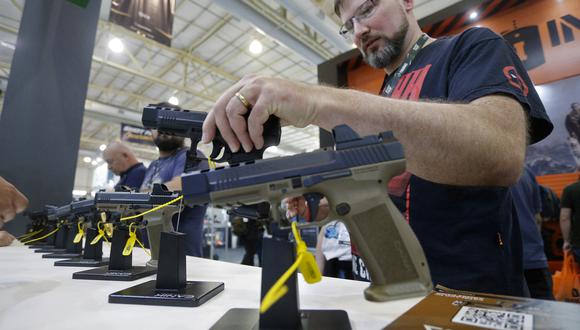 En esta foto del 5 de agosto de 2022, un visitante sostiene un arma durante la Shot Fair Brasil, una exhibición de armas realizada en el Centro de Convenciones y Exposiciones Expoville en Joinville, estado de Santa Catarina, Brasil. (Foto por Albari ROSA / AFP)