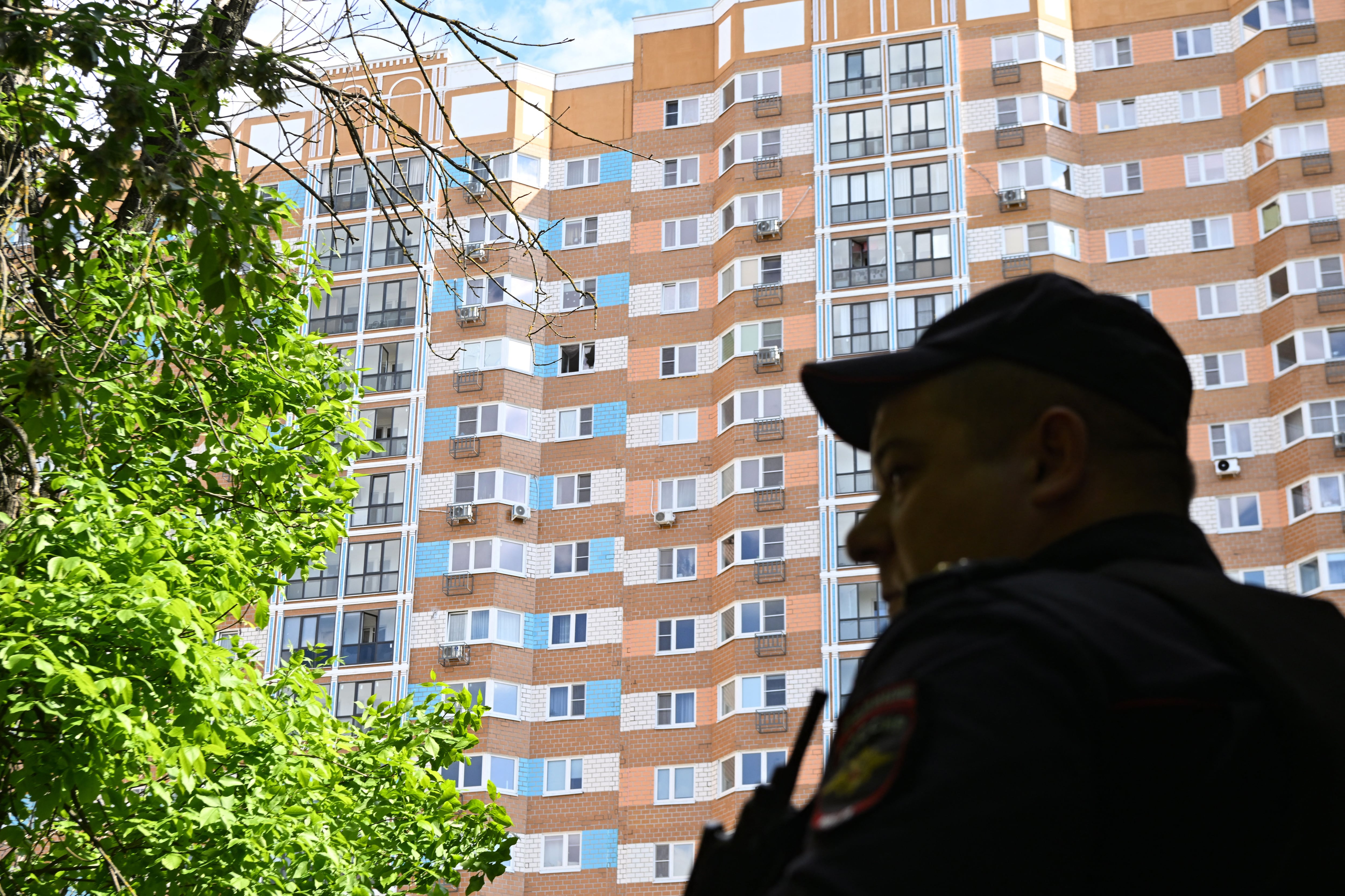 A police officer stands guard outside a multi-story apartment building after a drone strike in Moscow on May 30, 2023. (Photo by Kirill KUDRYAVTSEV / AFP)