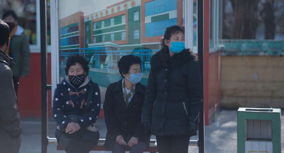Los pasajeros vestidos con máscaras esperan en una estación de tranvía en Pyongyang. (AFP).