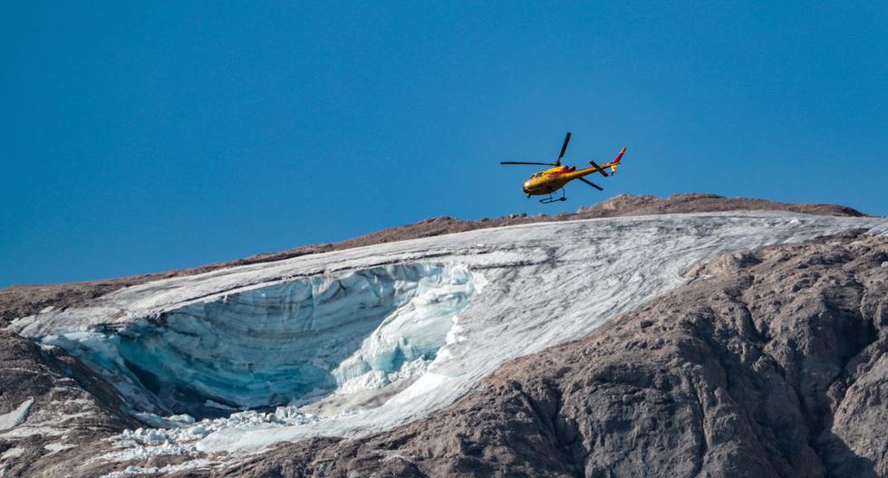 Un helicóptero de rescate italiano vuela el 4 de julio de 2022 sobre el glaciar que se derrumbó en la montaña de Marmolada, la más alta de los Dolomitas. (PIERRE TEYSSOT / AFP).