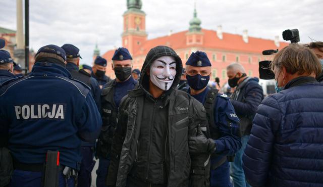 Las protestas contra las restricciones en Polonia acabaron con 380 detenciones. En la imagen podemos observar a una persona con una máscara durante su captura. (EFE/EPA/MARCIN OBARA POLAND OUT)