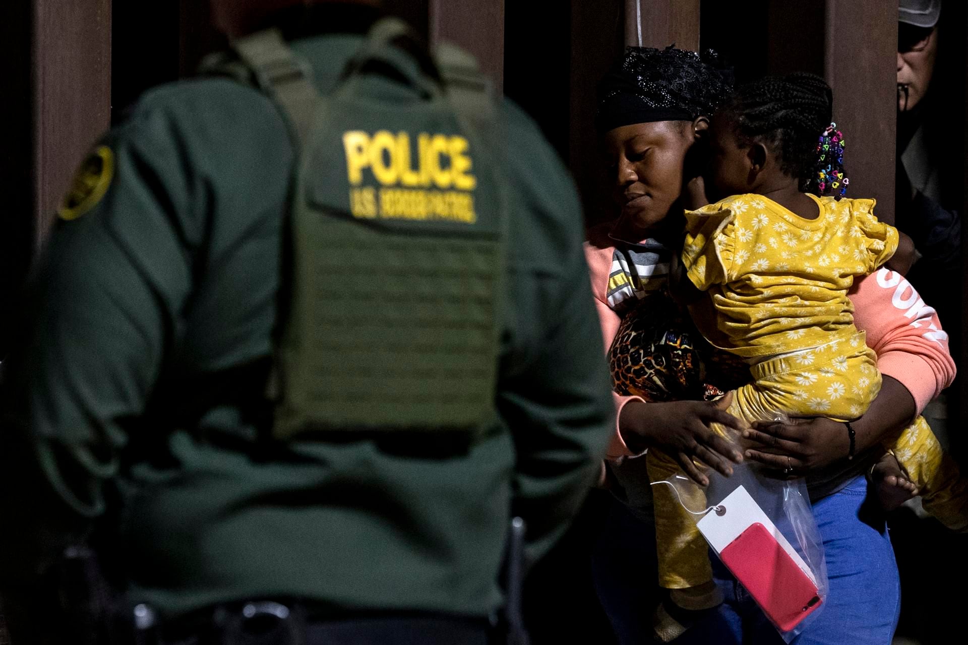 A family of Ghanaian migrants waits for Border Patrol agents to process them after crossing into the US illegally in Yuma, Arizona.  (EFE/EPA/ETIENNE LAURENT).