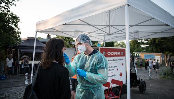 Una mujer es fotografiada al ser rexaminada para detectar el coronavirus en una estación de prueba móvil junto a un club nocturno en el distrito de Kreuzberg, en Berlín el 23 de julio de 2021, en medio de la pandemia de coronavirus en curso. (Foto de STEFANIE LOOS / AFP)