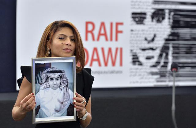 Ensaf Haidar sostiene la imagen de su esposo, Raif Badawi, quien creó un un sitio web de debate político y social fue condenado a recibir mil latigazos y a 10 años de cárcel. (AFP)