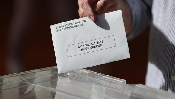 Un votante deposita su voto en el colegio electoral de Barcelona, el 28 de mayo de 2023 durante las votaciones locales y autonómicas. (Foto de Lluis GENE / AFP)