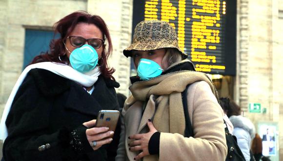 Dos viajeras usan mascarillas protectoras en la Estación Central de Milán, Italia, país que ha reportado contagios por coronavirus. (EFE / EPA / MATTEO BAZZI).