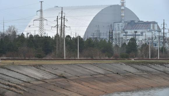 Una fotografía tomada el 13 de abril de 2021 muestra la cúpula protectora gigante construida sobre el sarcófago que cubre la central nuclear de Chernobyl en Ucrania. (Serguéi SUPINSKY / AFP).