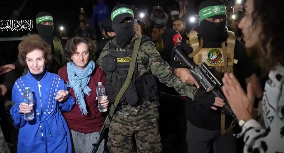 Combatientes de Hamas entregando rehenes ruso-israelíes recién liberados a la Cruz Roja, en la Franja de Gaza el 29 de noviembre de 2023. (Foto de OFICINA DE MEDIOS DE HAMAS / AFP)