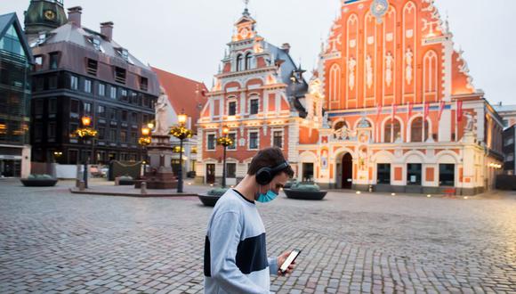 Un hombre que usa mascarilla facial pasa por una plaza vacía durante el primer día de restricciones por la pandemia de coronavirus en Riga, Letonia, el 9 de noviembre del 2020. (Gints Ivuskans / AFP).