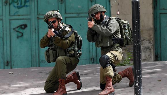 Imagen referencial. Dos policías apuntan con sus armas durante los enfrentamientos registrados con palestinos en la ciudad cisjordana de Hebrón, el 20 de abril del 2018. EFE/Abed Al Hashlamoun