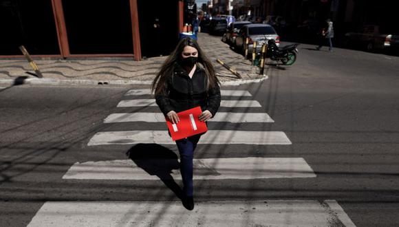 Una mujer con tapabocas cruza una calle hoy, por el centro de Asunción (Paraguay). (Foto: EFE/ Nathalia Aguilar).