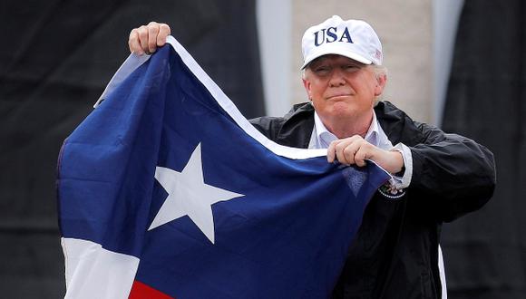 Donald Trump ondeó una bandera de Texas al llegar a la zona devastada por el paso de Harvey. (Foto: Reuters)