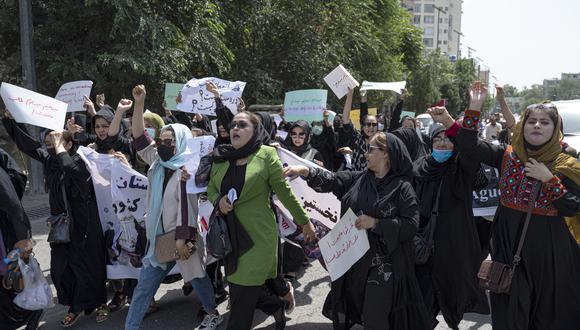 Las mujeres afganas sostienen pancartas mientras marchan y gritan lemas "Pan, trabajo, libertad" durante una protesta por los derechos de las mujeres en Kabul el 13 de agosto de 2022. (Foto de Wakil KOHSAR / AFP)