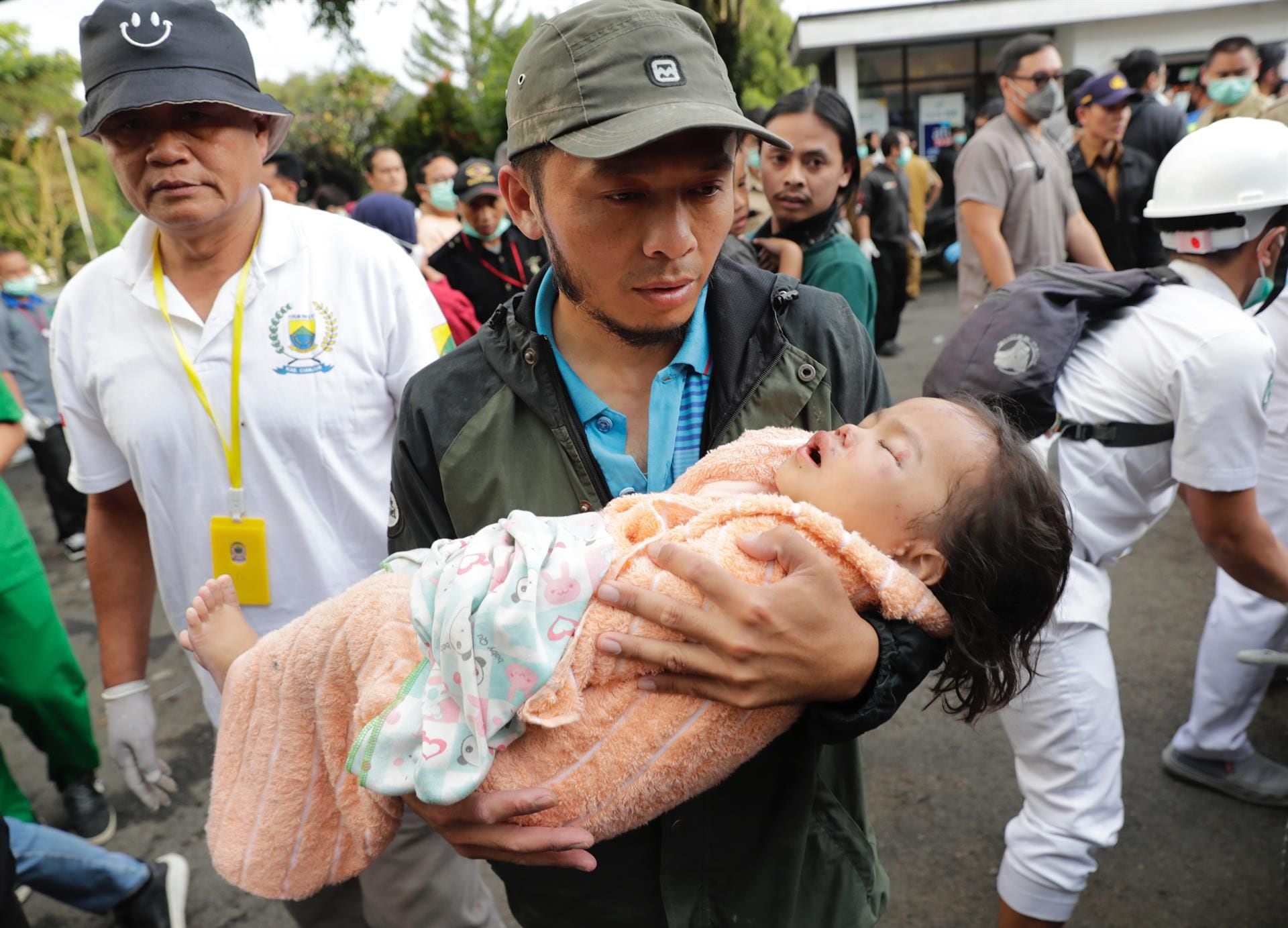 Rescue teams carry a girl victim of the earthquake that hit Cianjur, Indonesia, on November 21, 2022. (EFE/EPA/ADI WEDA).