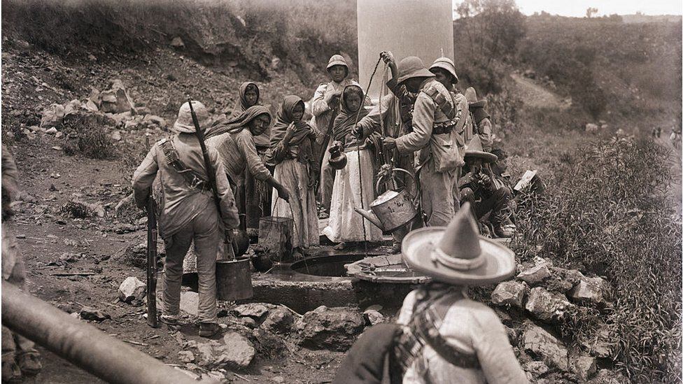 Women and men draw water from a well during the Mexican revolution.  (GETTY IMAGES)