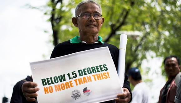 Un activista ambiental exhibe un cartel durante una manifestación frente al edificio de las Naciones Unidas en Bangkok, donde se desarrolla una conferencia climática de la ONU. (Foto: AFP)