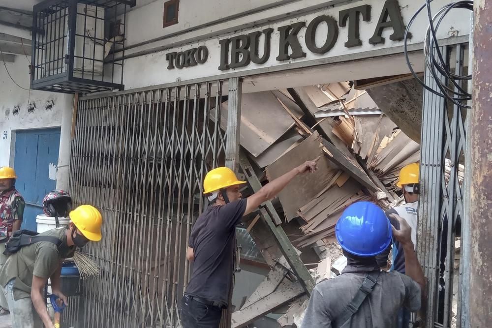 Workers inspect a shop damaged during the earthquake in Cianjur, West Java, Indonesia, Monday, Nov. 21, 2022. (AP Photo/Firman Taqur)