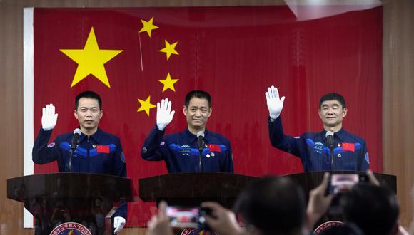 Los astronautas chinos, Tang Hongbo, Nie Haisheng y Liu Boming, saludan en una conferencia de prensa en el Centro de Lanzamiento de Satélites de Jiuquan antes del lanzamiento de Shenzhou-12. (AP / Ng Han Guan)