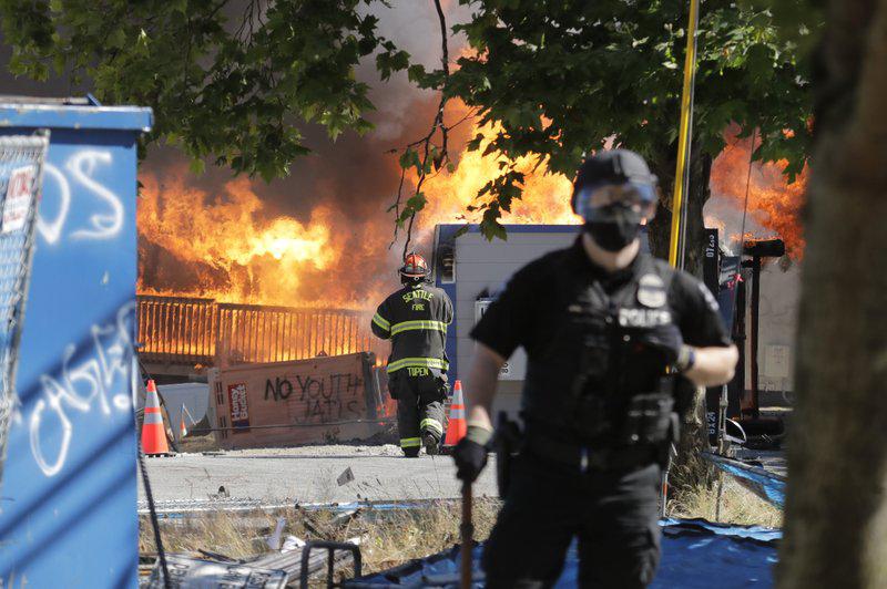 Contenedores son quemados cerca del Centro de Detención Juvenil del Condado de King, el sábado 25 de julio de 2020, en Seattle, poco después de que un grupo de manifestantes abandonara el área. Un gran grupo de manifestantes marchó el sábado en apoyo de Black Lives Matter y contra la brutalidad policial y la injusticia racial. (Foto AP / Ted S. Warren).