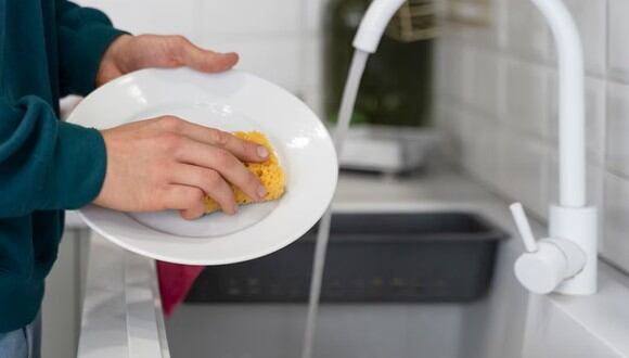 Una persona lavando platos. | Imagen referencial: Freepik