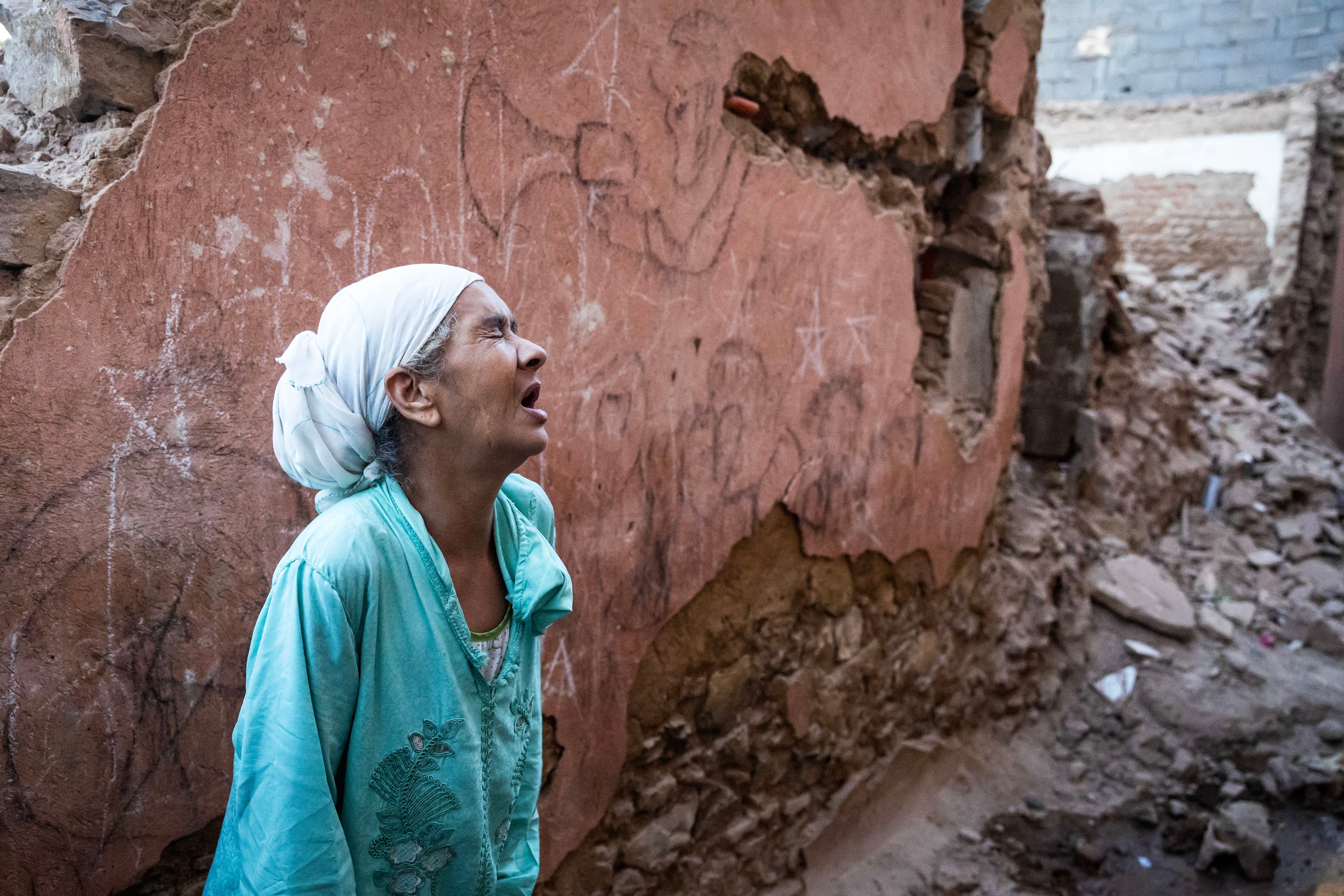 A woman reacts in front of her house damaged by the earthquake in the old city of Marrakech, in Morocco, on September 9, 2023. (Photo by FADEL SENNA / AFP).