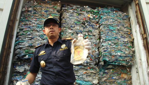El funcionario de aduanas de Indonesia muestra los desechos plásticos de los contenedores en el puerto internacional de Yakarta el 18 de septiembre de 2019.  (Foto: AFP)