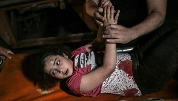 Los palestinos llevan a una niña herida después de un ataque aéreo de Israel en la ciudad de Gaza, el 16 de mayo de 2021. (EFE / EPA / MOHAMMED SABRE).