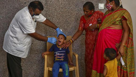 Un trabajador sanitario toma una muestra a un niño para una prueba de detección del coronavirus en Hyderabad, India, el 29 de abril de 2021. (AP Foto/Mahesh Kumar A.).