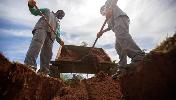 Brasil: Trabajadores colocan arena en una tumba en el cementerio Campo de Esperanza, en Brasilia, de alguien que falleció por coronavirus. (Foto: EFE/Joédson Alves).