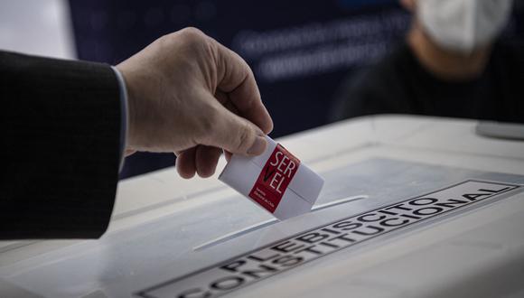 Un miembro del Servel (Servicio Electoral) muestra cómo emitir su voto en un colegio electoral antes del referéndum del próximo domingo en Santiago.