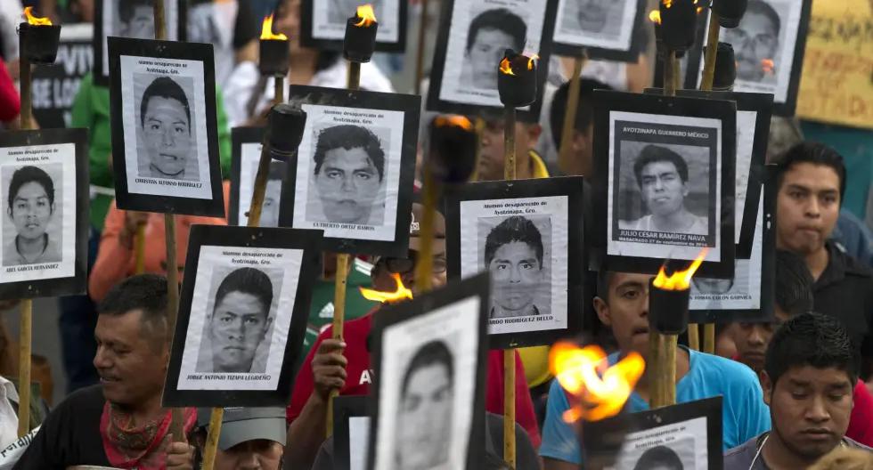 Familiares de los 43 estudiantes de Ayotzinapa desaparecidos en el sur de México muestran sus fotos durante una marcha para demandar justicia el 26 de abril de 2016. (AP Foto/Rebecca Blackwell, Archivo).