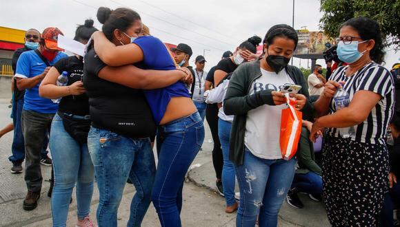 Familiares de reos asesinados se consuelan mientras esperan información en las afueras de la morgue de Guayaquil, Ecuador. (EFE/Juan Diego Montenegro).