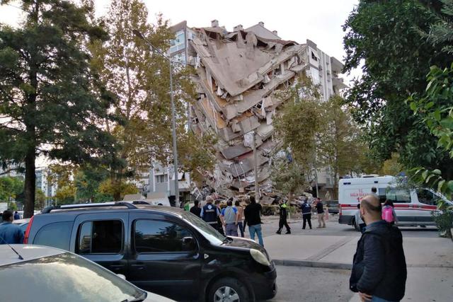 Los lugareños de Esmirna observan un edificio dañado después de que un fuerte terremoto azotó el mar Egeo el viernes y se sintió tanto en Grecia como en Turquía. (REUTERS/Tuncay Dersinlioglu).
