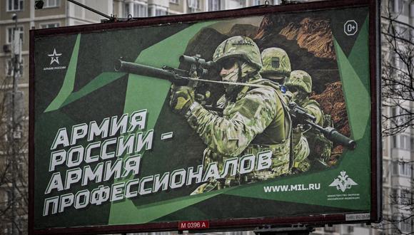 Una fotografía tomada el 24 de octubre de 2022 muestra un cartel que muestra soldados rusos con el lema "Ejército de Rusia". (Foto de Yuri KADOBNOV / AFP)