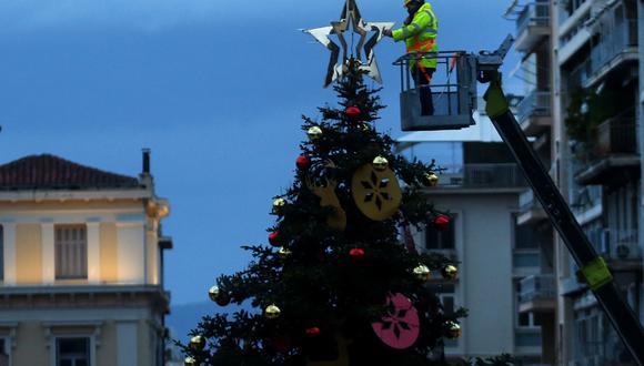 Un trabajador municipal decora el árbol navideño en la plaza Syntagma. Imagen tomada el domingo 13 de diciembre del 2020. (EFE/EPA/ORESTIS PANAGIOTOU)
