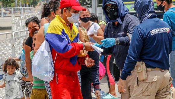 Funcionarios de migración colombianos revisan los documentos de los venezolanos en el Puente Internacional Simón Bolívar, en Cúcuta, Colombia, el 21 de agosto de 2020. (Schneyder MENDOZA / AFP).