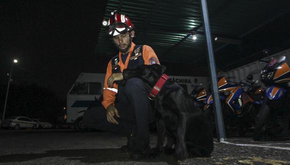 Un miembro de Protección Civil y un perro, parte de un grupo de rescatistas, en San Cristóbal, estado Táchira, Venezuela el 6 de septiembre de 2022. (Foto por JOHNNY PARRA / AFP)