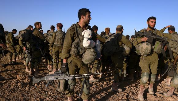 Un soldado israelí lleva un animal de peluche mientras se reúne con otros soldados después de salir de la Franja de Gaza, cerca de la frontera en el sur de Israel el 12 de marzo de 2024. (Foto de Menahem Kahana / AFP)