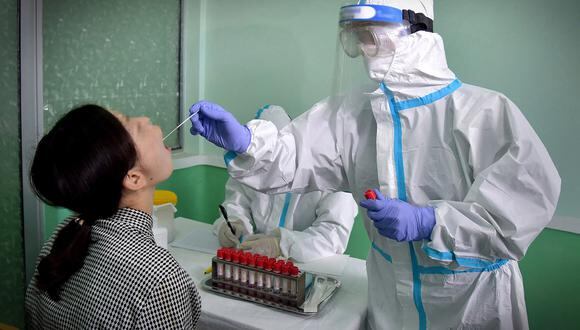 Personal de la Estación de Saneamiento y Cuarentena de la ciudad de Pyongyang realizando pruebas para detectar infecciones por coronavirus COVID-19 en Pyongyang, el 10 de junio de 2022. (Foto de KCNA VIA KNS / AFP)