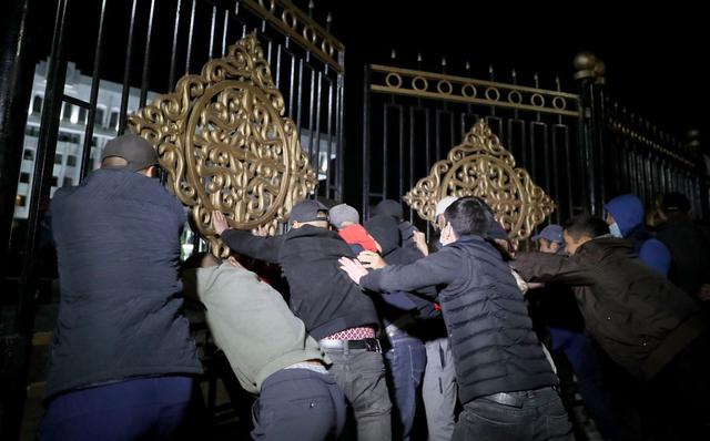 Manifestantes de la oposición contra los resultados de las elecciones parlamentarias asaltan las puertas de la Casa de Gobierno en el centro de Bishkek, Kirguistán. (EFE/IGOR KOVALENKO).