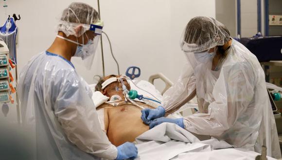 Enfermeras de la Unidad de Pacientes Críticos revisan la intubación de un paciente infectado con coronavirus en el Hospital El Carmen, en Santiago. (Foto: JAVIER TORRES / AFP)