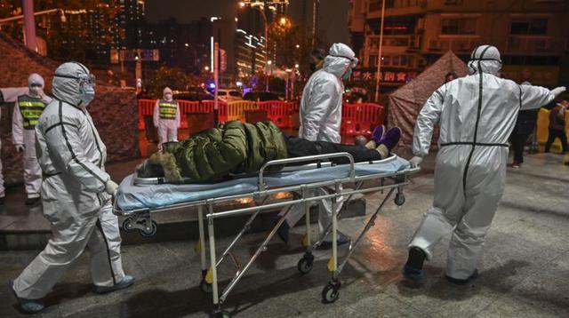 Medical staff members wearing protective clothing to help stop the spread of a deadly virus which began in the city, arrive with a patient at the Wuhan Red Cross Hospital in Wuhan on January 25, 2020. - The Chinese army deployed medical specialists on January 25 to the epicentre of a spiralling viral outbreak that has killed 41 people and spread around the world, as millions spent their normally festive Lunar New Year holiday under lockdown. (Photo by Hector RETAMAL / AFP)