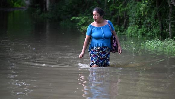 Una mujer camina por una calle inundada después del paso de la tormenta tropical Pilar en la aldea de Los Ángeles, en Zacatecoluca, El Salvador, el 1 de noviembre de 2023. (Foto de Marvin RECINOS / AFP).
