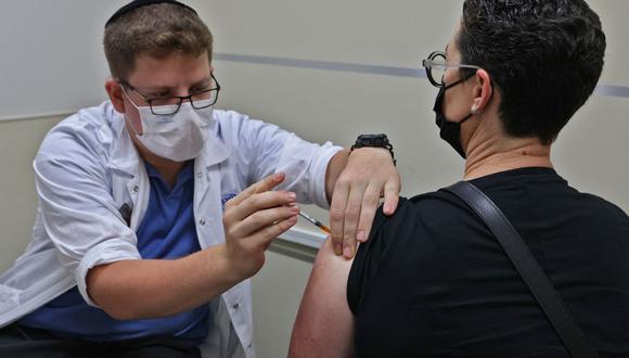 Un trabajador de la salud israelí administra una tercera dosis de la vacuna Pfizer-BioNtech a un hombre, en el Servicio de Salud Maccabi en Jerusalén (Israel), el 20 de agosto de 2021. (Foto de  AHMAD GHARABLI / AFP).